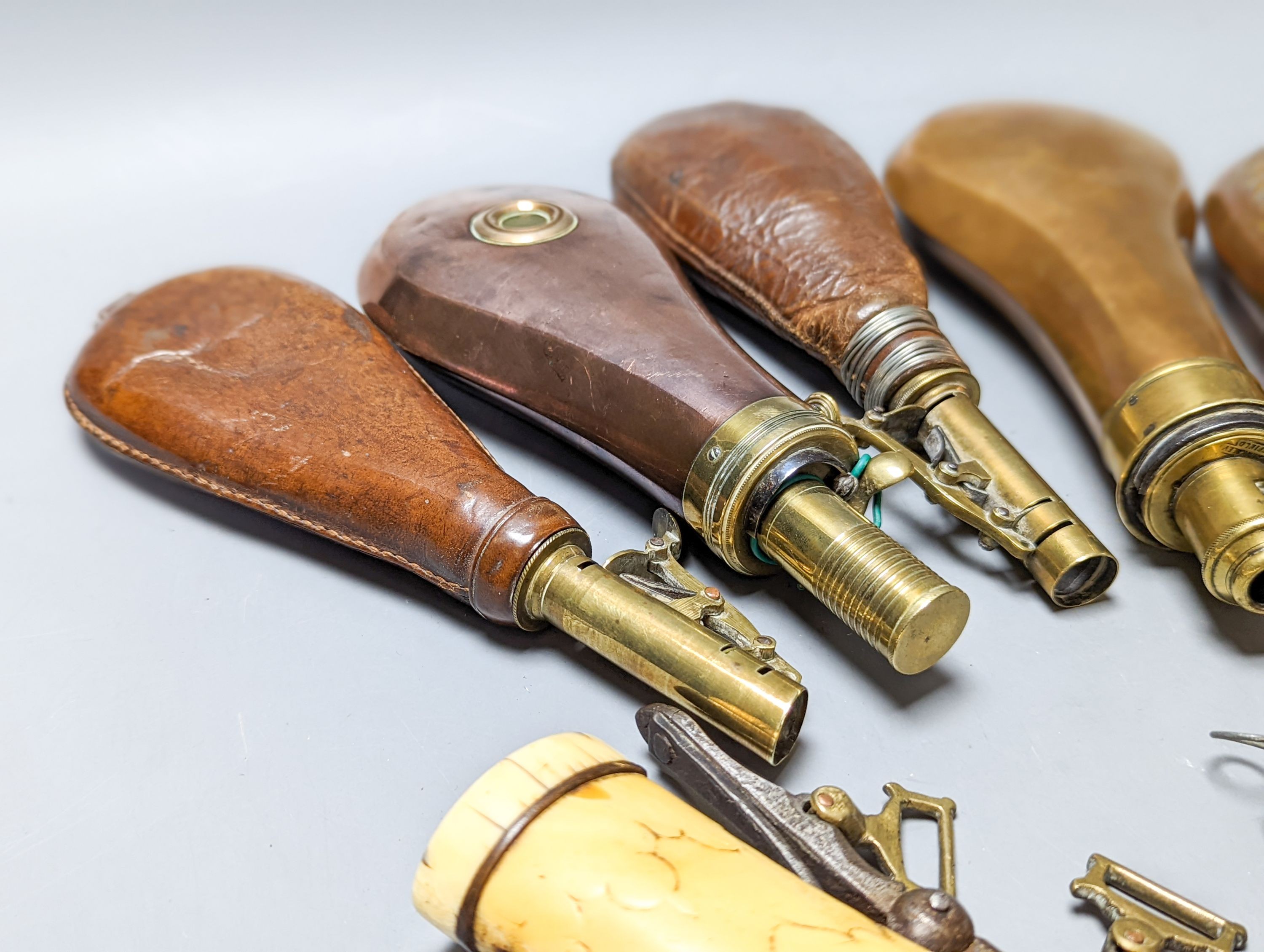 Six powder/shot flasks, 4 copper and brass, 2 leather and brass, together with a carved powder horn (7)